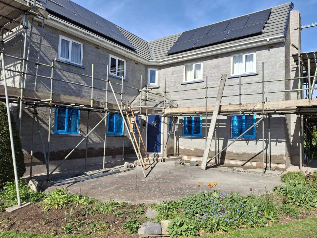 House being rendered, with scaffolding